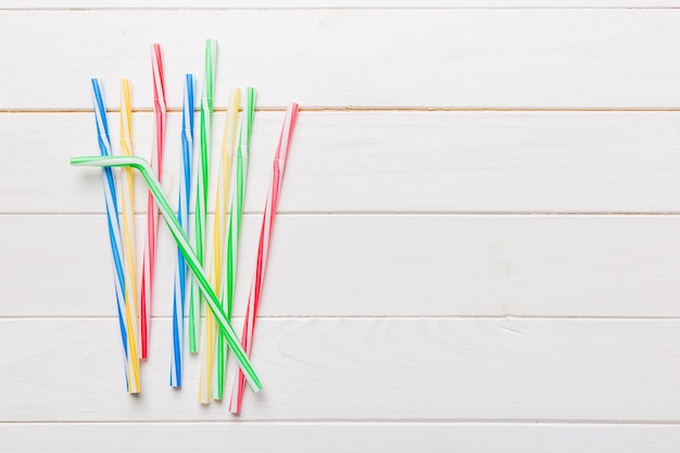 Drinking straws for party on Colored background Top view of colorful plastic disposable straws for summer cocktails different straws for juice with copy space