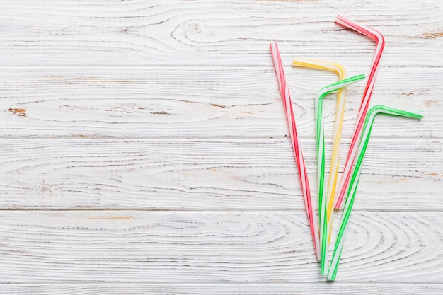 Drinking straws for party on Colored background Top view of colorful plastic disposable straws for summer cocktails different straws for juice with copy space