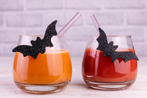 Drinks for Halloween in glasses decorated with black bats.