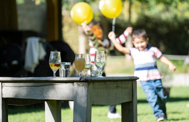 Drinks on a table during a party Happy children running with yellow balloons on blurred background