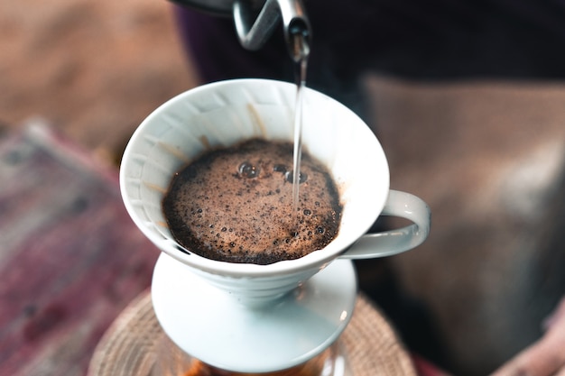 Drip coffee, barista pouring water on coffee ground with filter,brewing coffee