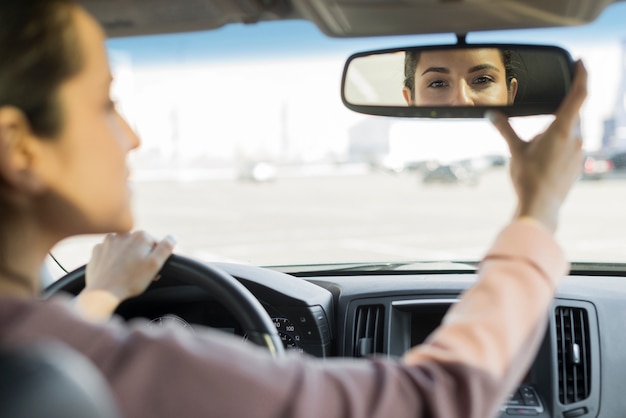 Driver adjusting the rear-view mirror