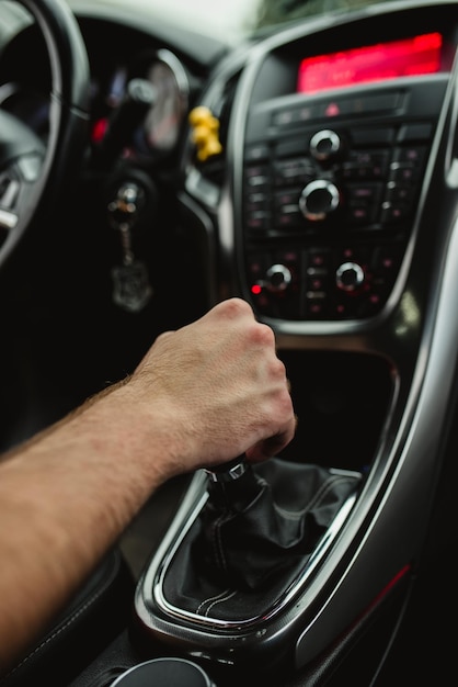 The driver holds his hand on the gear lever