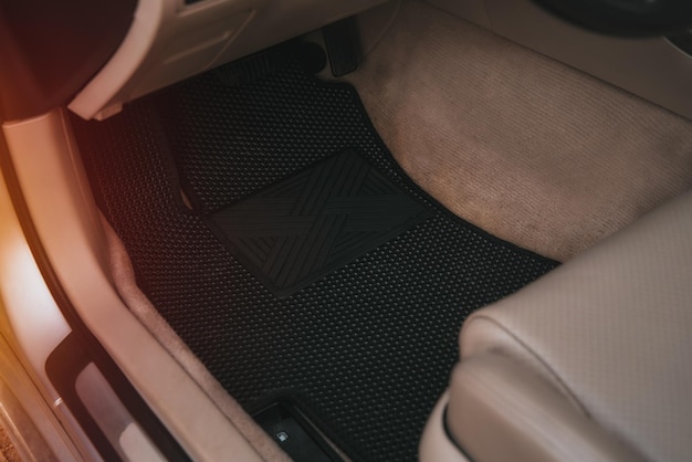 Driverside black floor mats made of ethylene vinyl acetate shortened for EVA Dark floor mats in the light interior of the car