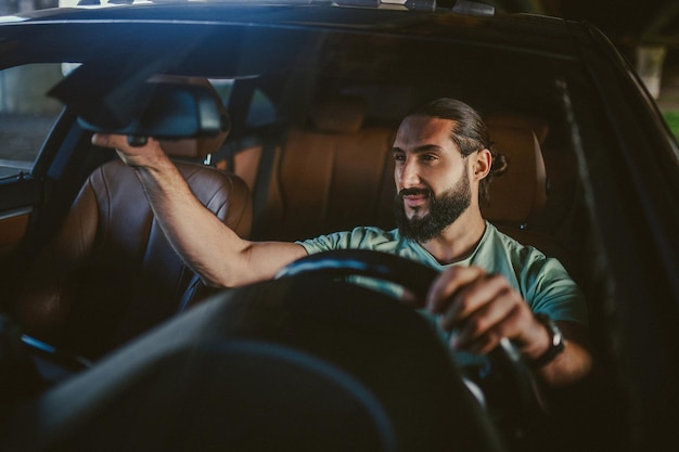 Driving a car Young handsome darkhaired man driving a car