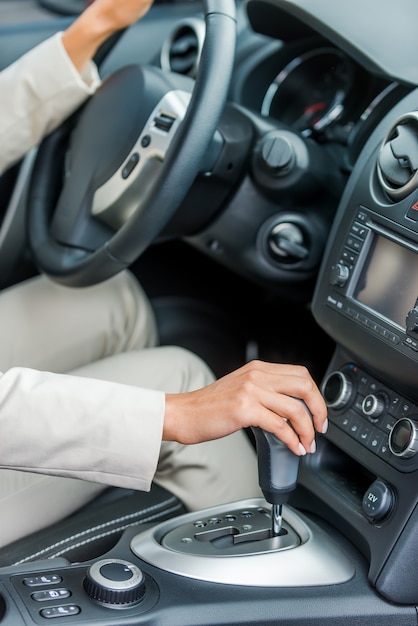 Driving her new car. Close-up of woman in formalwear driving car