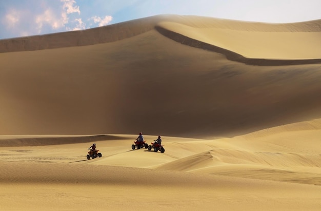 Driving offroad with quad bike or ATV vehicles Namib sand desert on the background