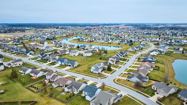 Drone aerial of suburban Midwest American neighborhood houses with ponds and housing addition