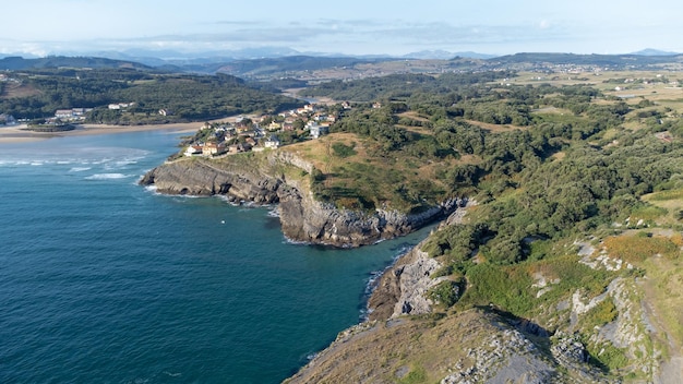 Drone aerial view of the cantabrian coast with the village and the beach in the background on a sunny summer day