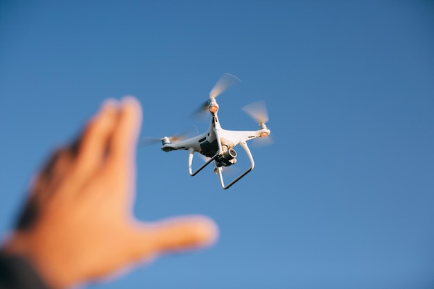 Drone copter with the camera flies in the blue sky