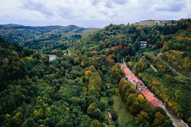 Drone flight over countryside with mountain village and agricultural fields at autumn season autumn