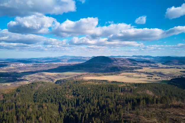 Drone flight over mountains covered with forest and valleys