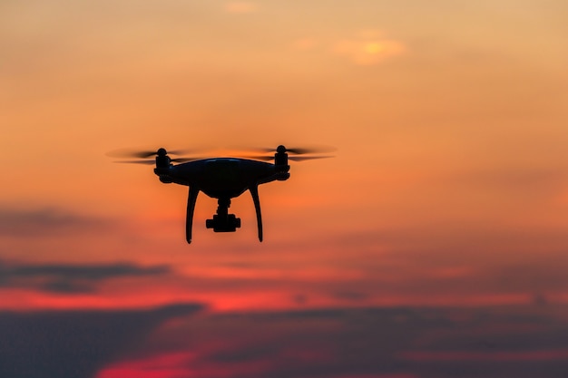 Drone flying over ocean at sunset time