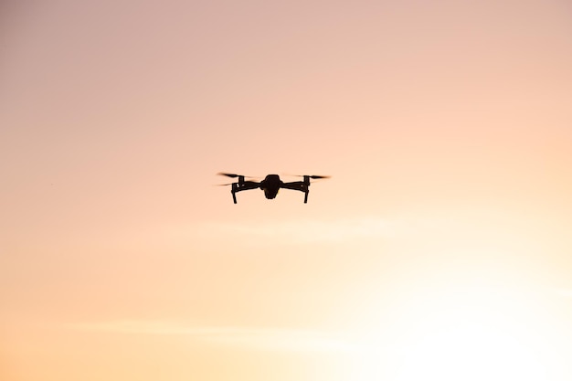 The drone is in flight at sunset Video shooting from above An article about the choice of a quadrocopter Pros and cons of the drone