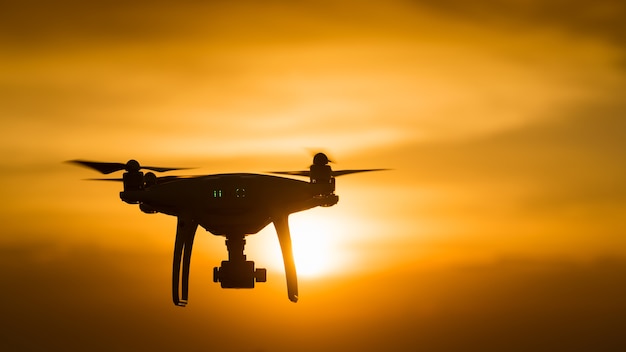 drone quad copter with digital camera at sunset 