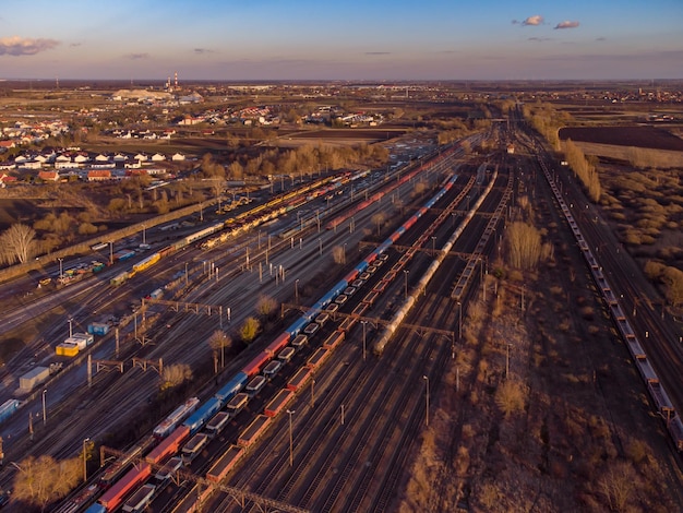 Photo drone shot over a railway sorting station with trains at sunset photo railway tracks with wagons top view aerial top view