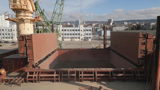 Drone video showcases the loading of a bulk carrier with grain by enormous cranes in a bustling port