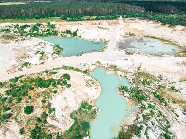 Drone view on a flooded kaolin quarry with turquoise water and white shore