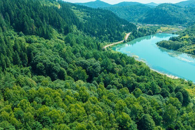 Drone view of a mountain river with a dam The mountains are covered with forest Mountain landscape in summer