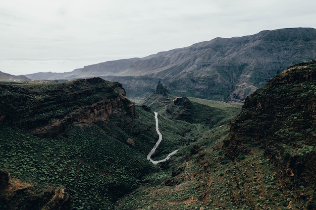 Drone view of savage road in the middle of the forest and mountains