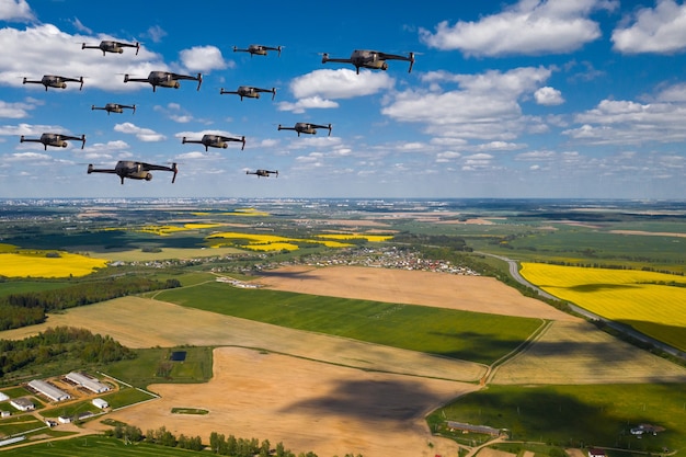 Drones fly over the fields. Natural landscape with drones and quadrocopters flying over it