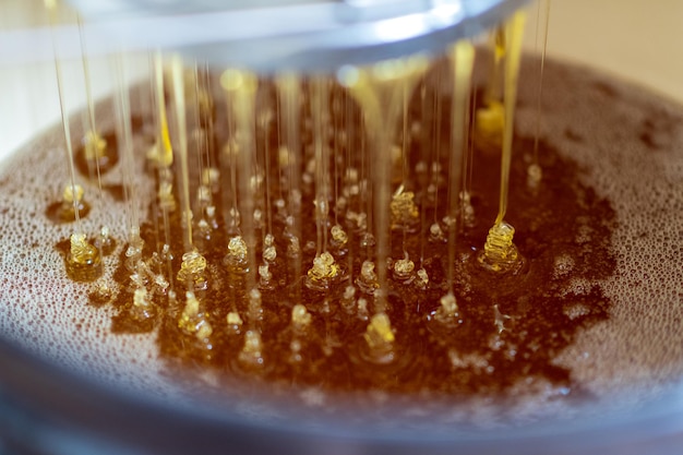 Photo drop of bee honey drip from hexagonal honeycombs