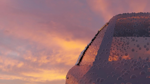 Droplets on a car body with sunset twilight sky in background