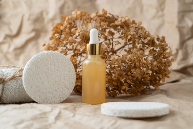 A dropper bottle with face serum with vitamin C or natural oil standing on a craft paper background