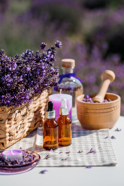 Dropper bottle with lavender cosmetic oil or hydrolate against lavender flowers field as background with copy space Herbal cosmetics and modern apothecary concept