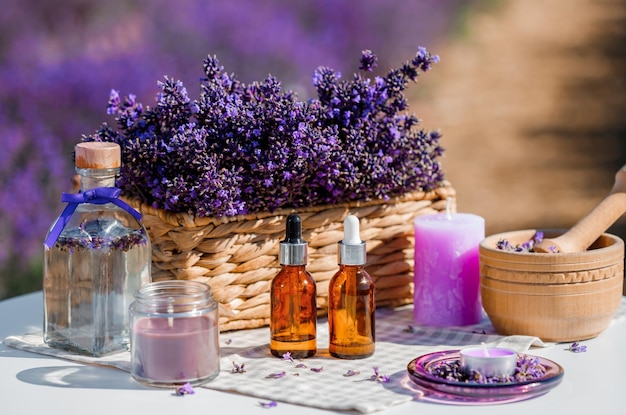 Dropper bottle with lavender cosmetic oil or hydrolate against lavender flowers field as background with copy space Herbal cosmetics and modern apothecary concept