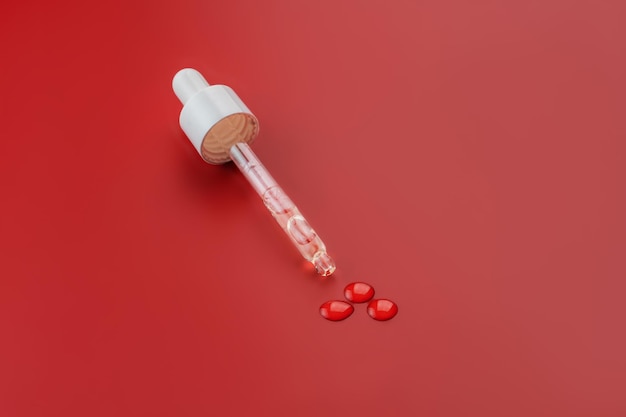 Dropper glass bottle cap mockup Cosmetic pipette red background Concept of anti age and beauty cosmetics minimalism skin care