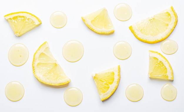 Drops of cosmetic serum and lemon slices White background Skin care product