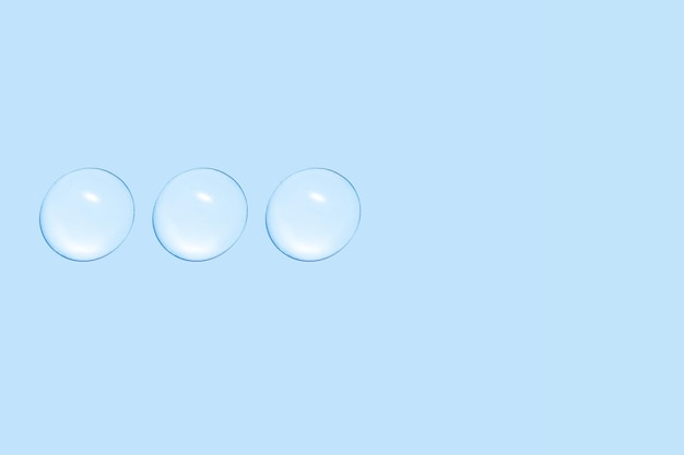 Drops of transparent gel or water in a row On a blue background