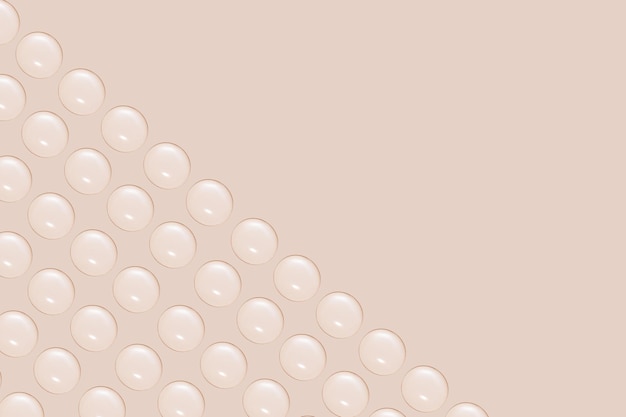 Drops of transparent gel or water in rows On a beige background