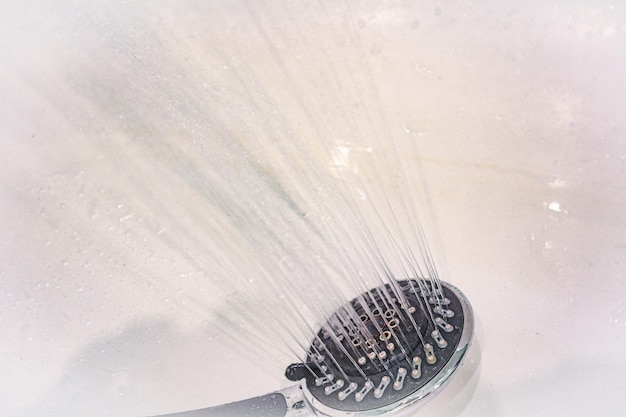 Drops of water fall from the watering can in the shower closeup The flow of water Big round watering can in the shower