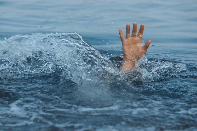 Drowning man reaching for help in sea closeup