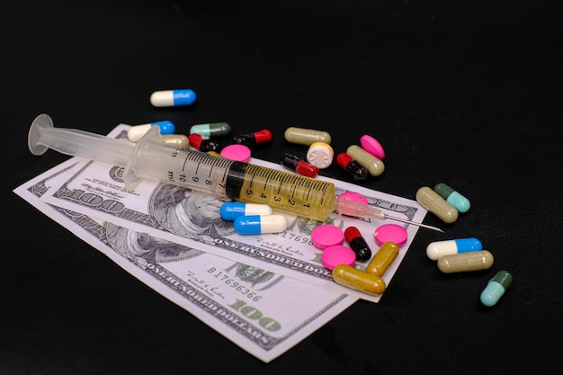 Drug medicine syringe and money banknote on the black background