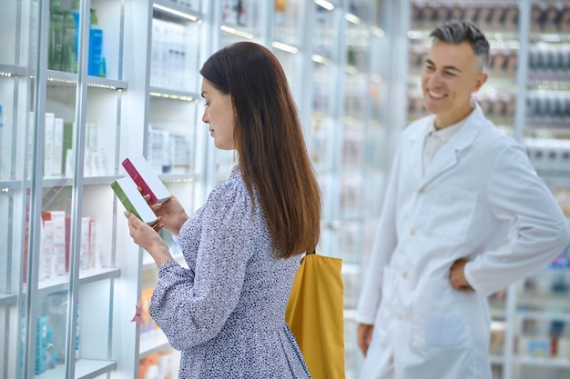 In a drugstore. Female customer choosing products in a drugstore