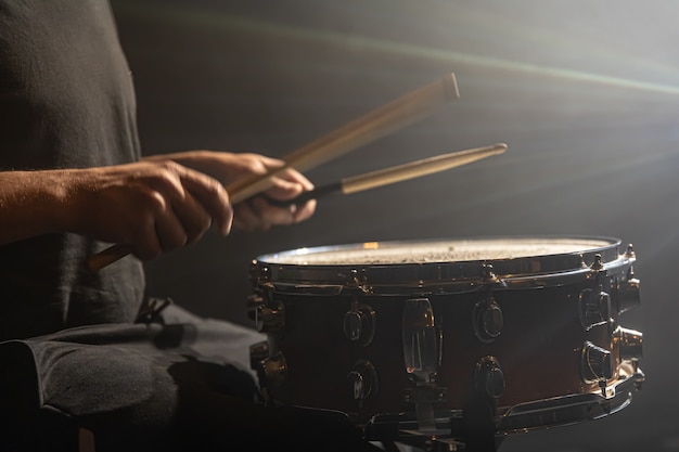 Drummer playing percussion, snare drum on stage in the spotlight, copy space.