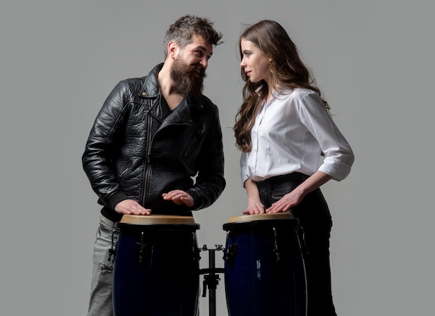 Drums conga music excited couple hitting on conga drums isolated on gray background