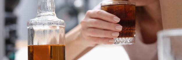 Drunk depressed alcoholic woman drinking whiskey alone at home