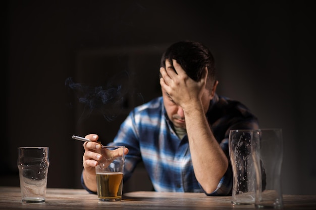 drunk man drinking alcohol and smoking cigarette