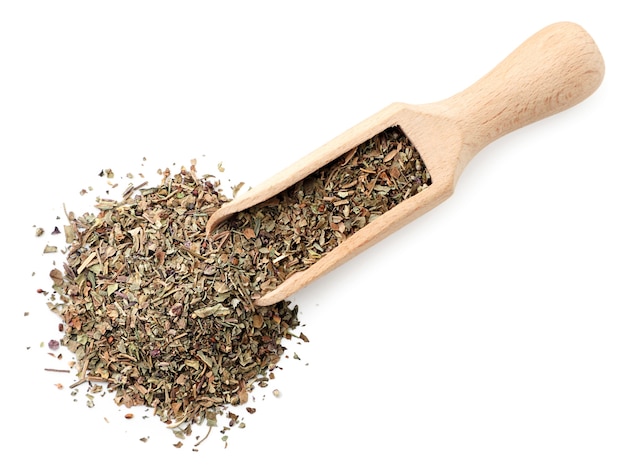 Dry basil in a spatula closeup on a white background, isolated. The view from top