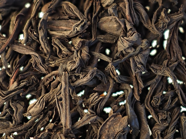 Dry black tea leaves background