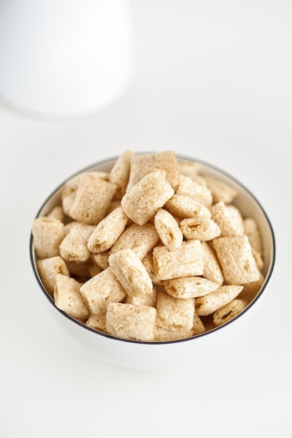 Dry breakfast cereal pads with milk on a light table. selective focus