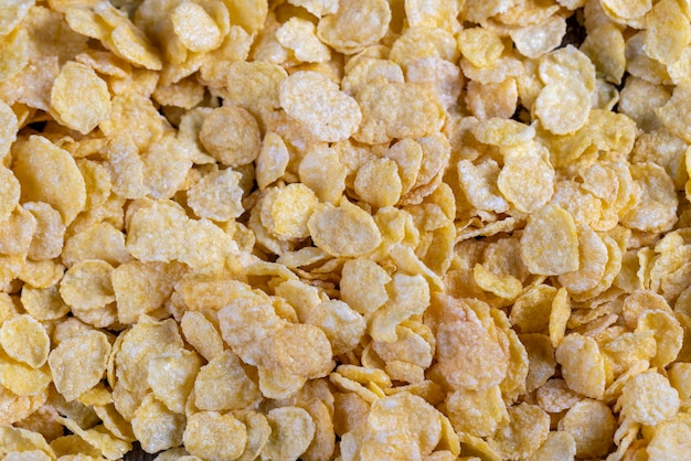 Dry breakfast corn flakes of yellow color close up