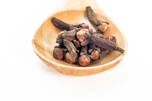 dry brown spice cloves on wooden spoon  cooking ingredients