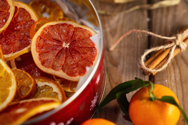 Dry citrus fruits and fresh mandarin on wooden table