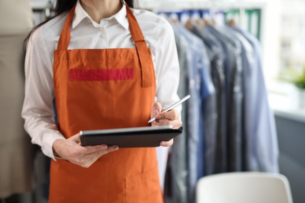 Dry cleaning administrator holds tablet with documents to sign