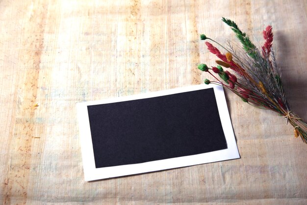 Dry flower with blank notebook on old wooden table Vintage tone